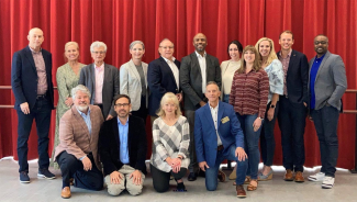 Council members in front of a red curtain.